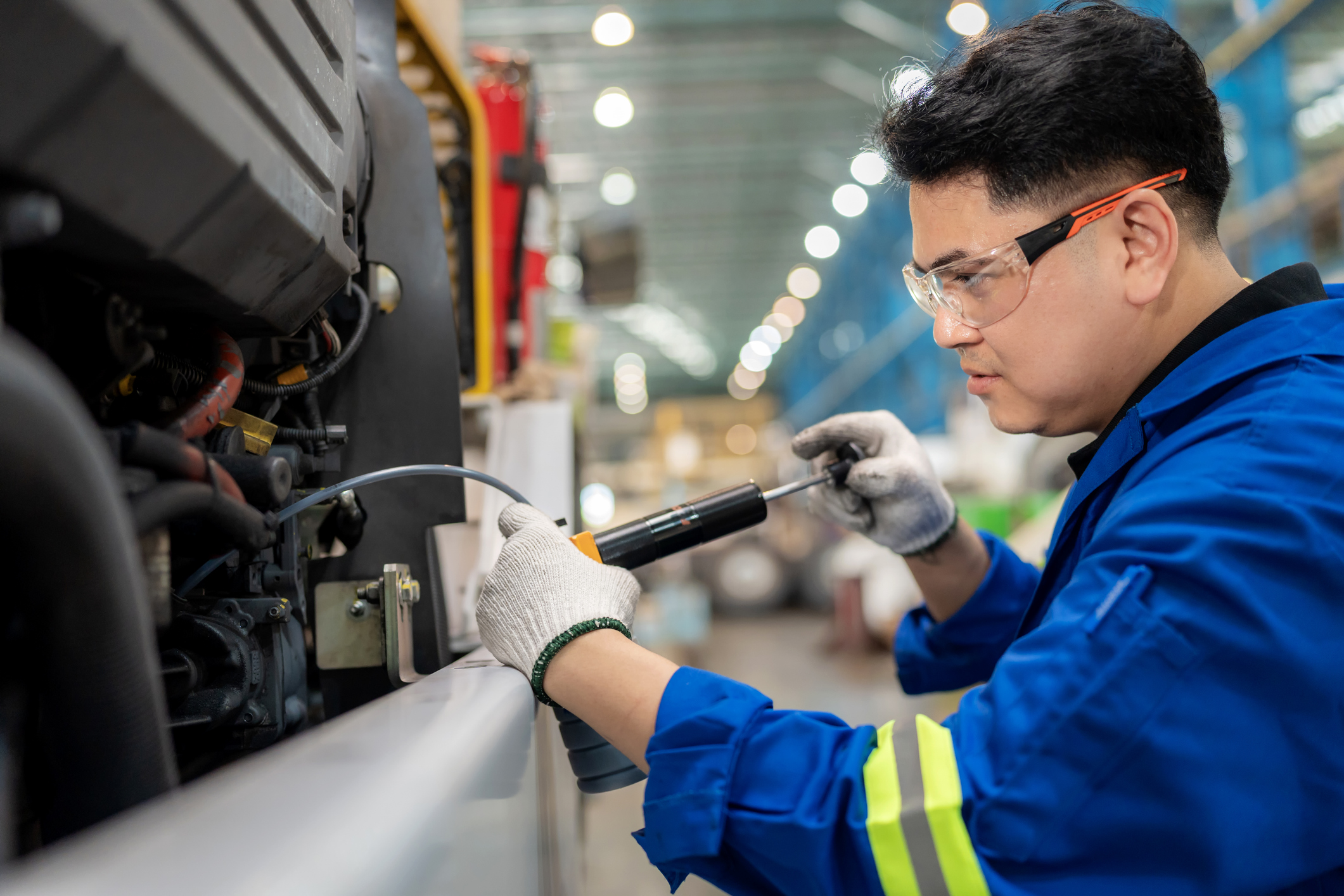 Professional engineer operates oil sampling pump with hose to gather used engine oil for testing. Scene of precision, safety, and expertise in industrial service, lubrication research, and mechanical quality inspection.